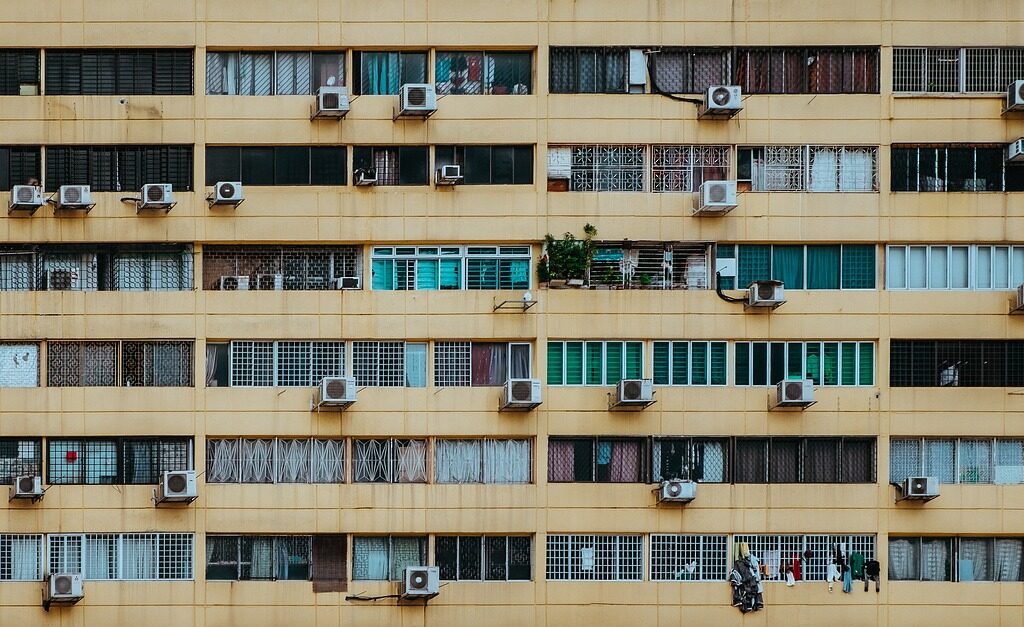 Fachada de un edificio con varias unidades exteriores de aire acondicionado instaladas, ejemplo habitual en comunidades de propietarios donde surgen dudas legales sobre su colocación.