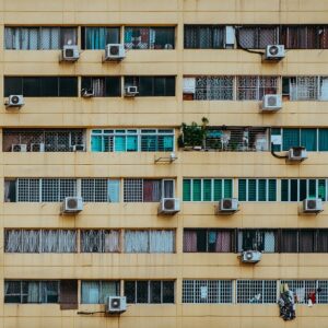 Fachada de un edificio con varias unidades exteriores de aire acondicionado instaladas, ejemplo habitual en comunidades de propietarios donde surgen dudas legales sobre su colocación.