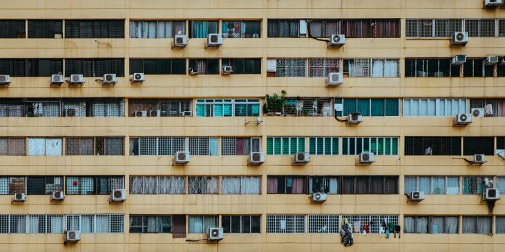 Fachada de un edificio con varias unidades exteriores de aire acondicionado instaladas, ejemplo habitual en comunidades de propietarios donde surgen dudas legales sobre su colocación.